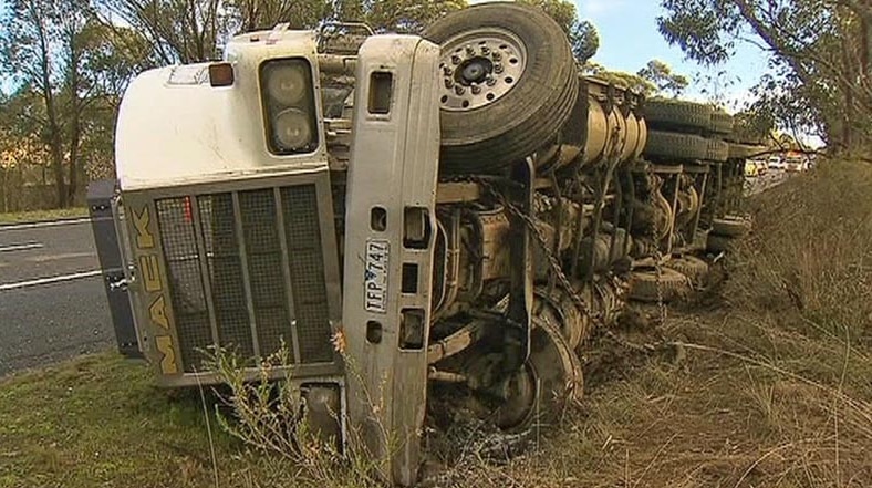 A truck rolls on its side after an accident on the Hume Highway