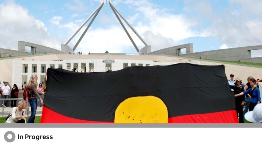 An Aboriginal flag is unfurled outside parliament house in Canberra