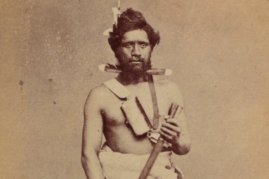 Old photograph of a Maori man holding a musket 