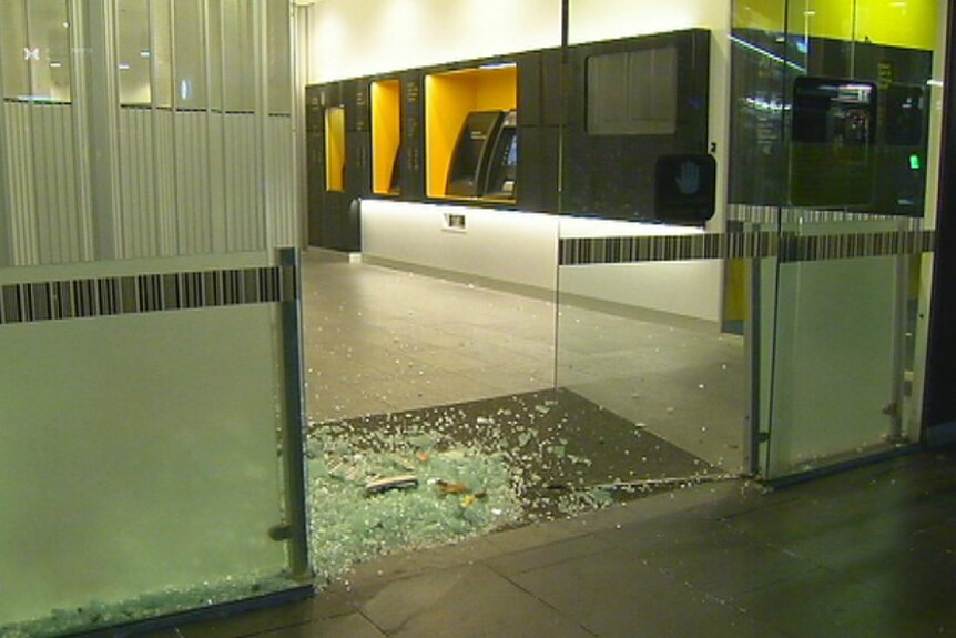 Shattered glass in the doorway of a Commonwealth Bank in Melbourne after a driver crashed into the front door.