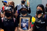 A group of people holding a framed picture of Aung San Suu Kyi