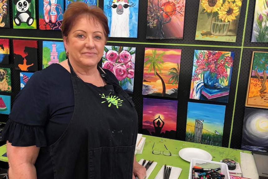 Linda Pearson stands in front of artworks at her business 'Your Creative Palette' at Rochedale.