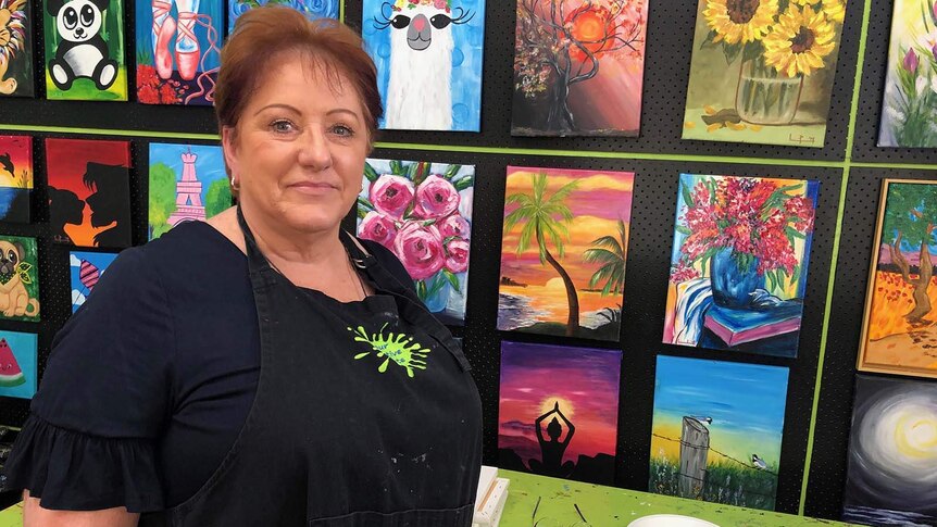 Linda Pearson stands in front of artworks at her business 'Your Creative Palette' at Rochedale.