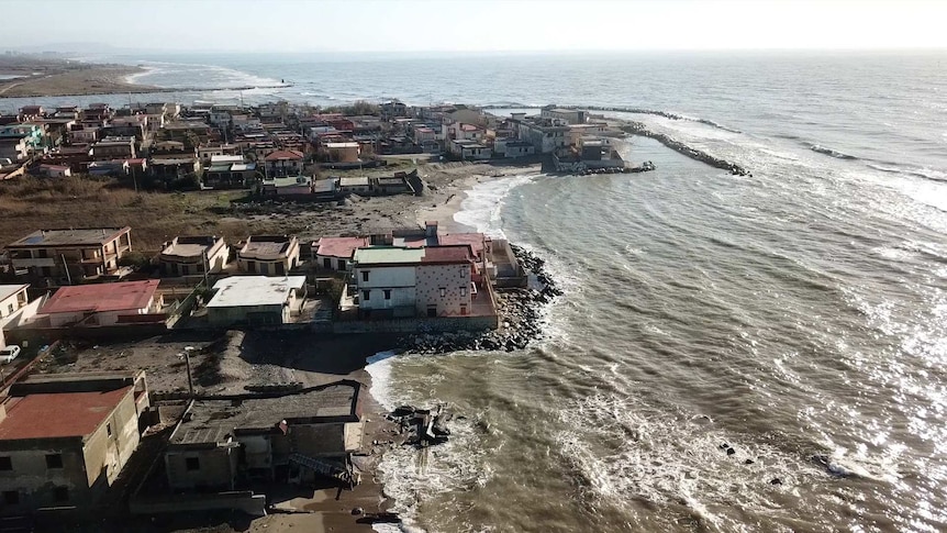 The beachfront of Castel Volturno with crumbling homes and piles of rubbish.