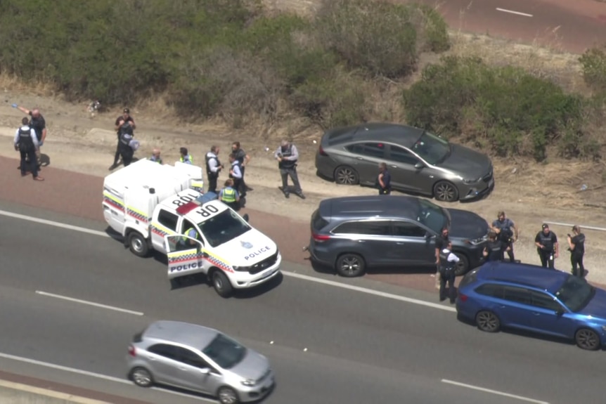 A dozen police officers and their vehicles on a Perth freeway where a man was arrested.