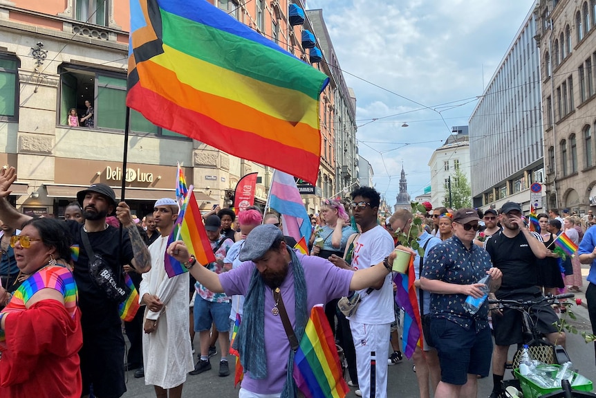 People wave rainbow flags while taking part in a march