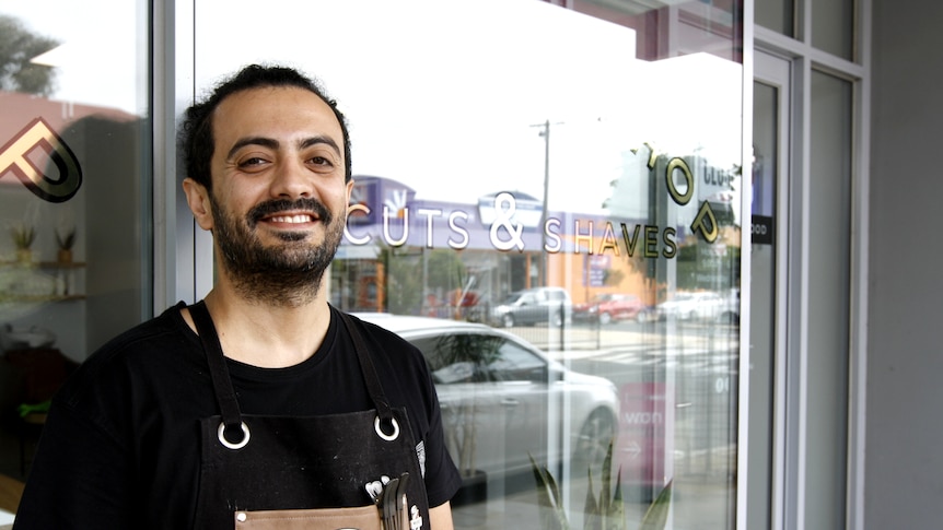 Behnam Nazifi stands in front of his shop