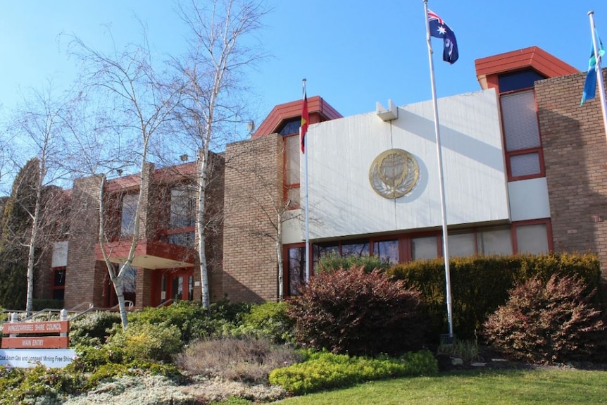 The front of the Wingecarribee Council chambers with a Australian flag flying on flag pole.