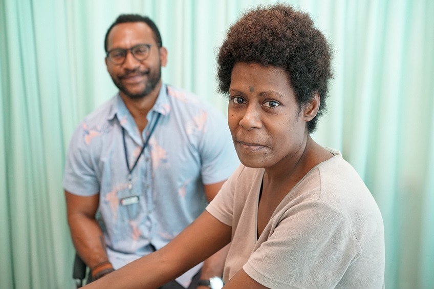 Dr Alfred Mel stands in the background with patient Philomina Isac.