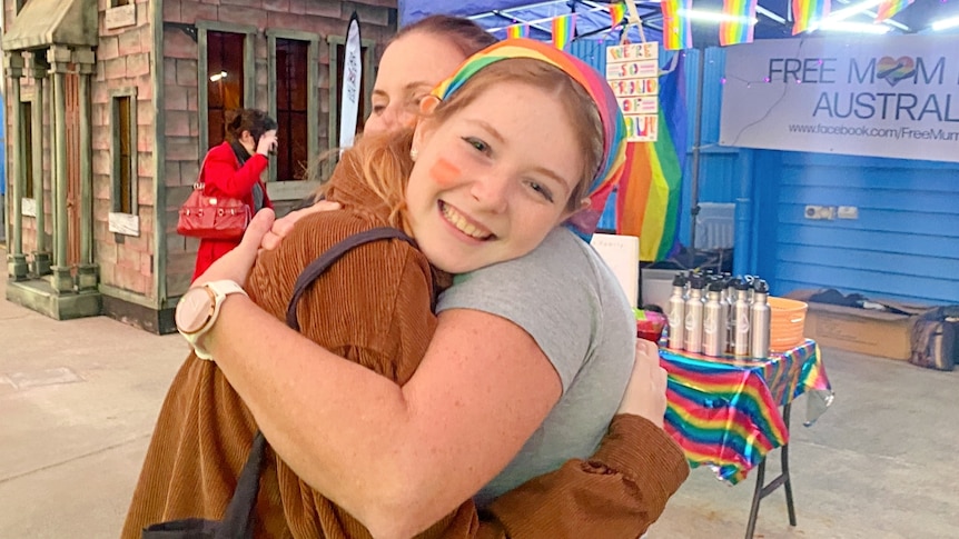 Young woman gets a hug from a mum