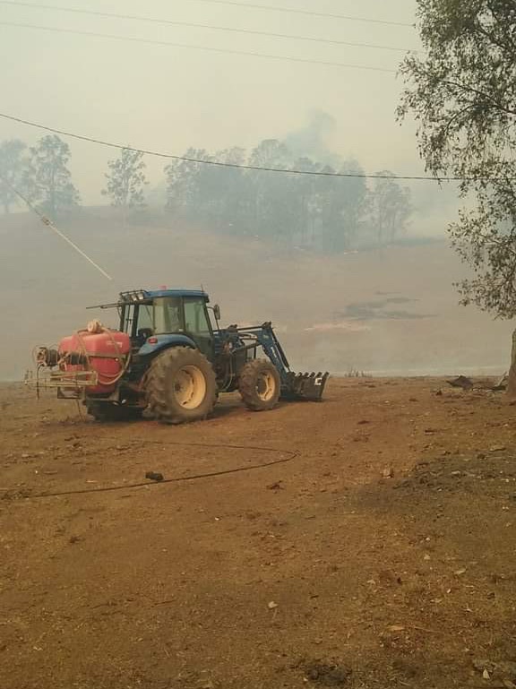 A green tractor with a water tank on the back