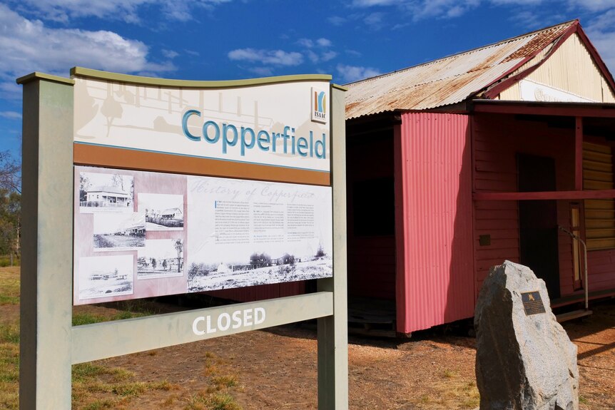 A sign with information for Copperfield next to a small outdoor dwelling