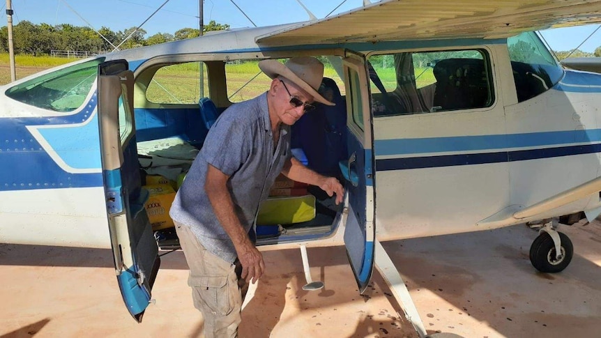 A pilot unloads pizzas from a plane at a remote NT cattle station.