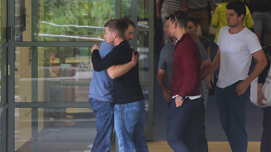 Steve Smith is consoled by Simon Katich outside St Vincent's Hospital