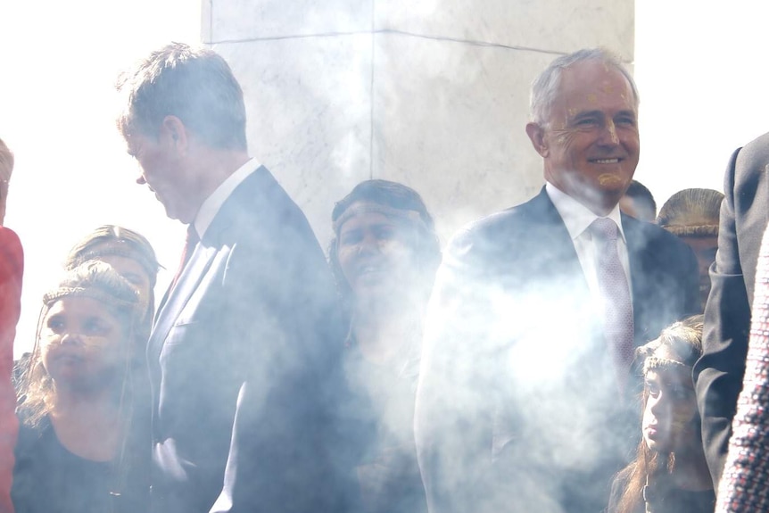 Malcolm Turnbull and Bill Shorten have their faces painted yellow at the smoking ceremony.