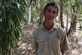 Kakadu tour guide Reuben Jones stands beside a tree in Kakadu National Park.