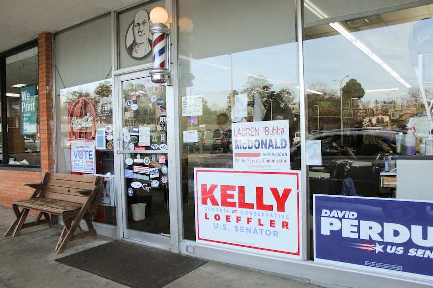 A glass window shop front with US politics signs for Kelly and David