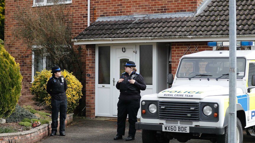 Police officers stand outside the house of former Russian double agent Sergei Skripal.