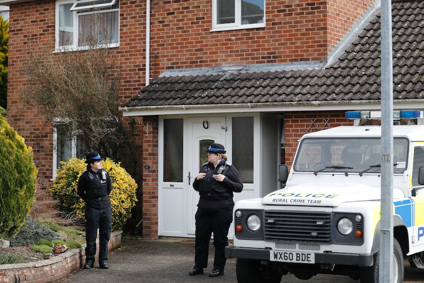 Police officers stand outside the house of former Russian double agent Sergei Skripal.