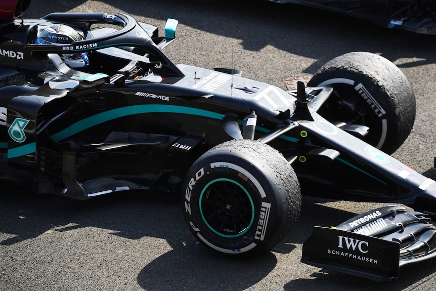 Valtteri Bottas sits in his Mercedes F1 car. The tyres are heavily bubbled.