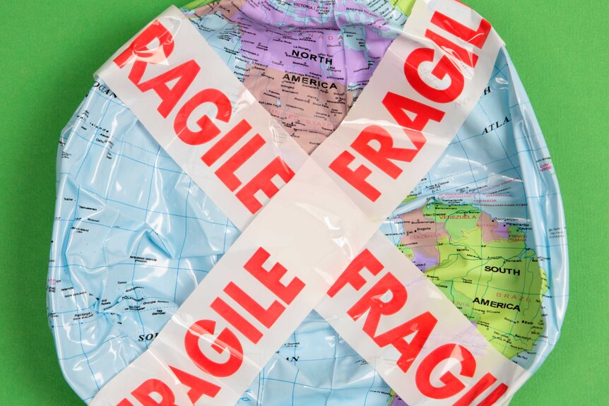 A deflated plastic globe with 'Fragile' tape criss-crossing it.