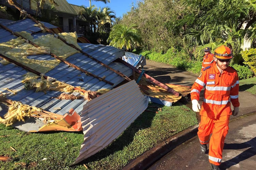 SES workers near roof debris on a front lawn in Mooloolaba