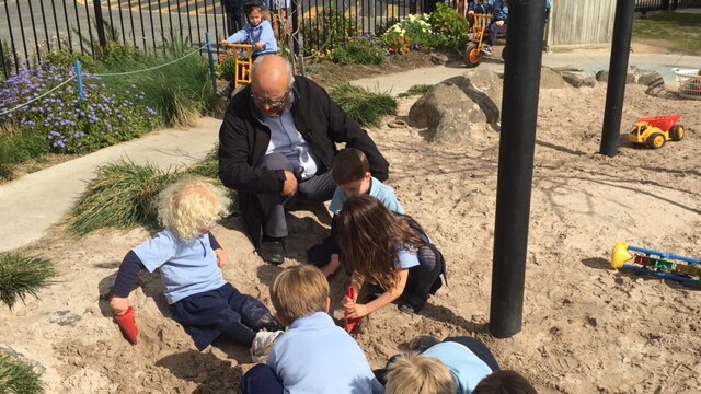 Professor Ted Melhuish in a sandpit with children