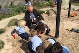 Professor Ted Melhuish in a sandpit with children
