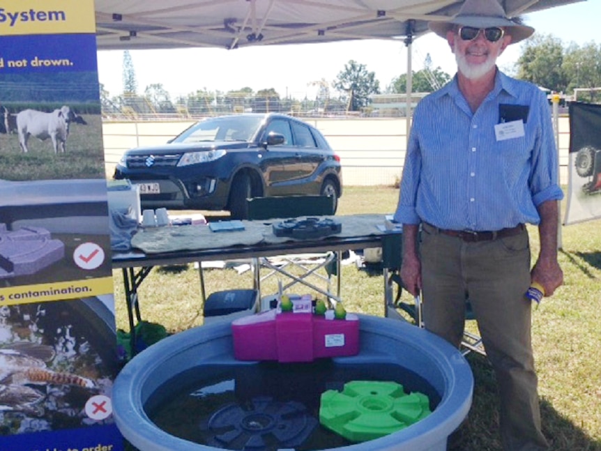 Bird expert Del Richards standing beside  a water tank containing his bird island invention