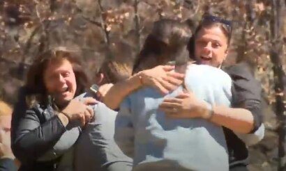Four women embrace and celebrate.