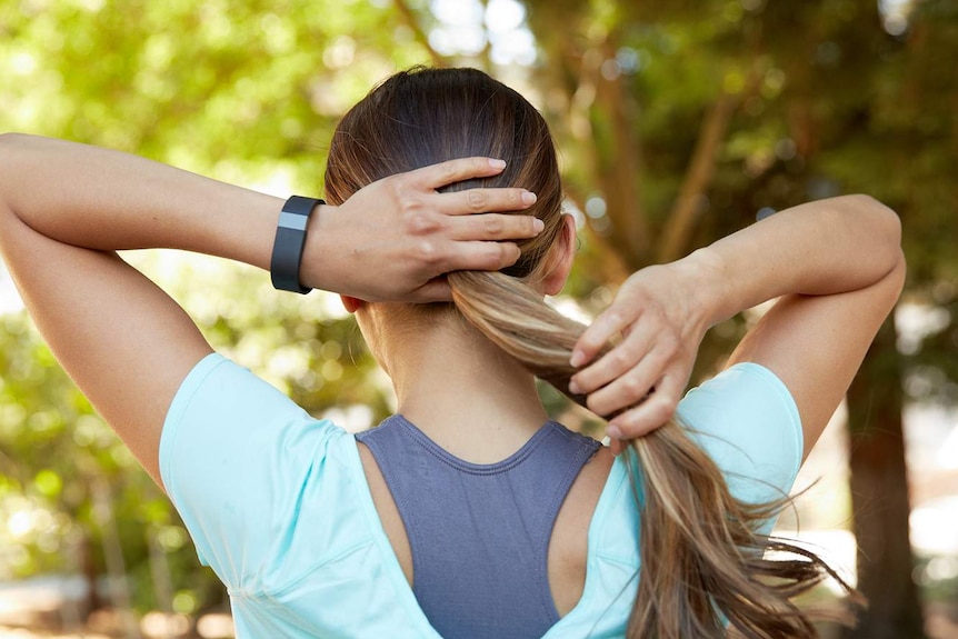 A woman with a Fitbit personal wellbeing tracker.