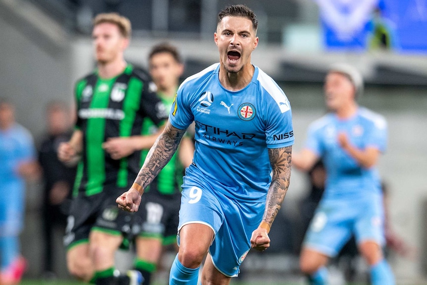 A Melbourne City A-League player yells out as he pumps his fists while celebrating a goal against Western United.