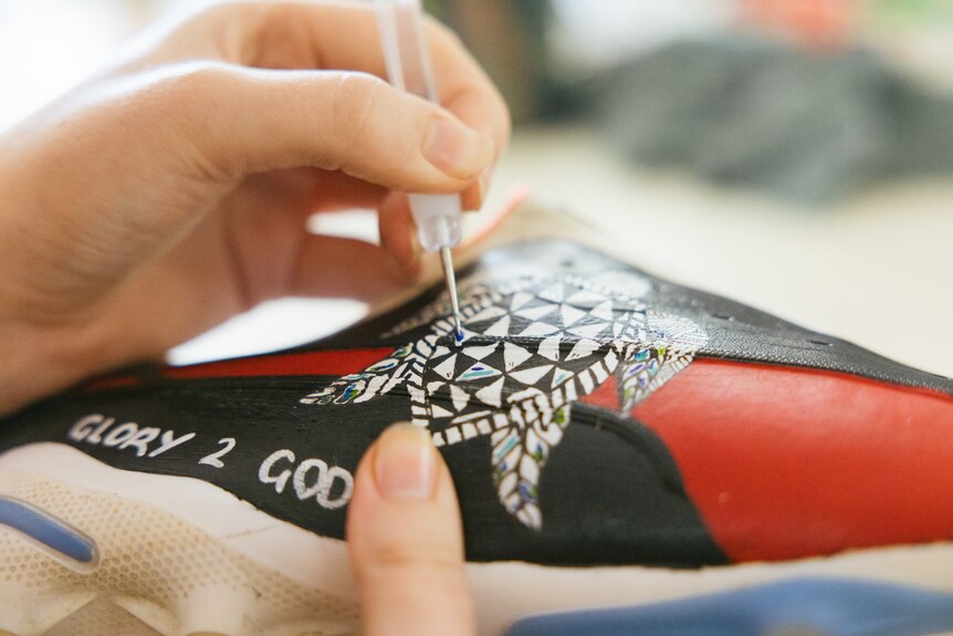 A close up of a specially painted football boot