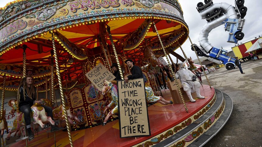 People ride a carousel at Dismaland, a theme park-styled art installation by British artist Banksy in the UK