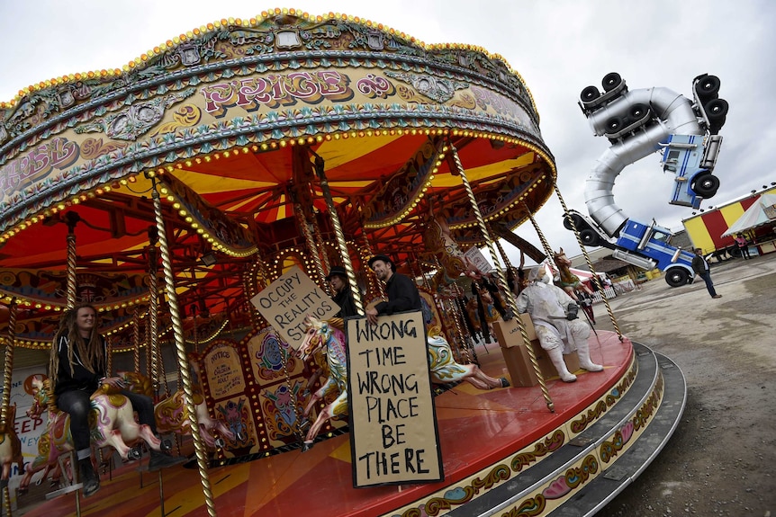 People ride a carousel at Dismaland, a theme park-styled art installation by British artist Banksy in the UK