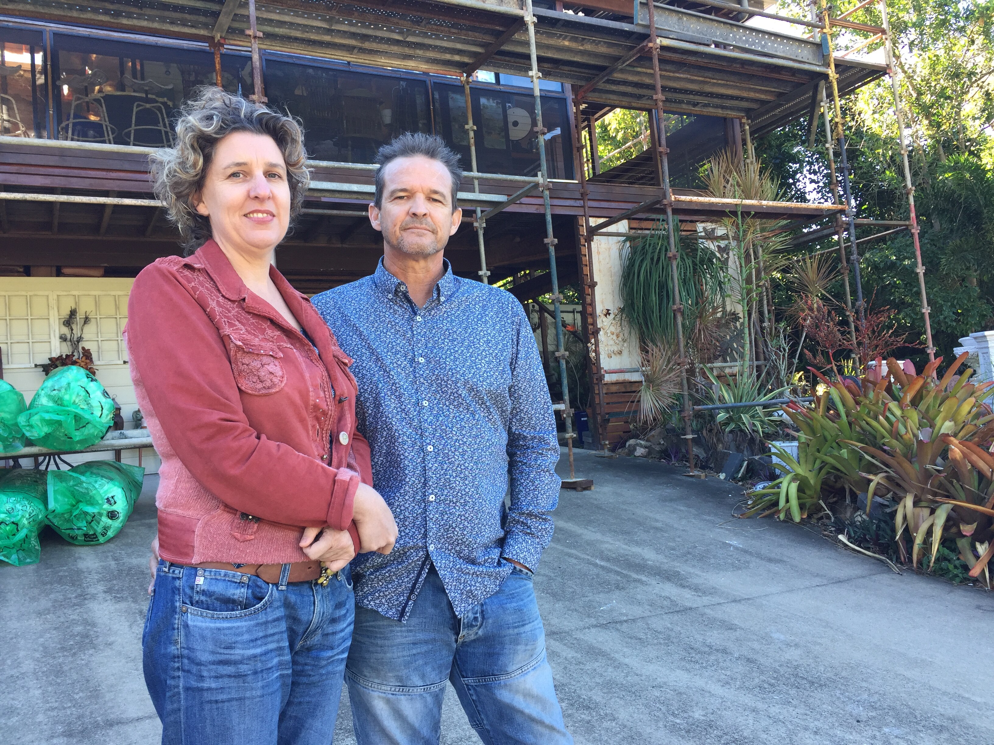 Kristel and Rod Taylor in front of their cyclone damaged house