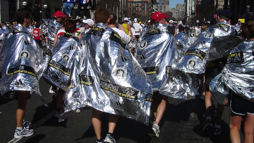 Marathon runners wearing space blankets.