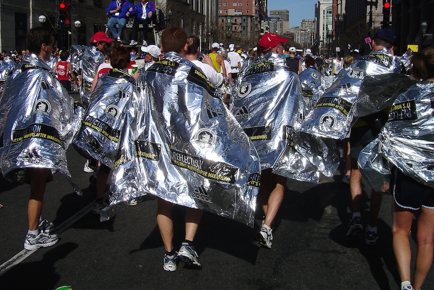 Marathon runners wearing space blankets.
