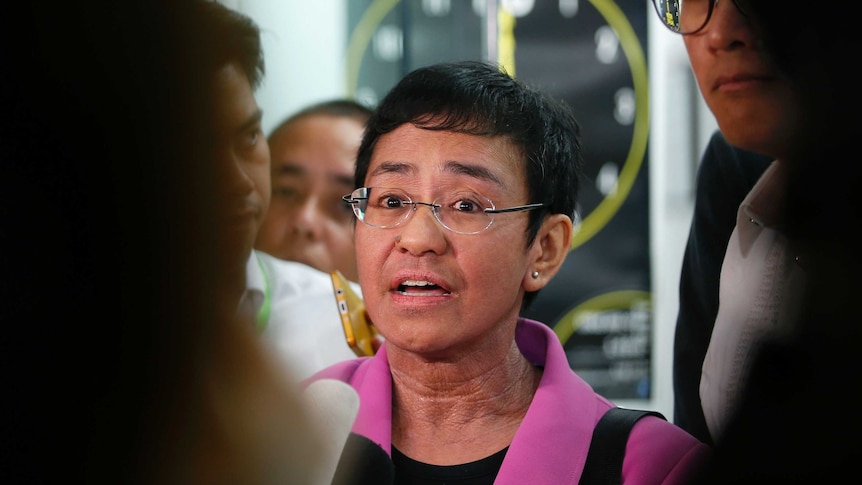 Medium shot of a woman speaking into a microphone giving an interview.