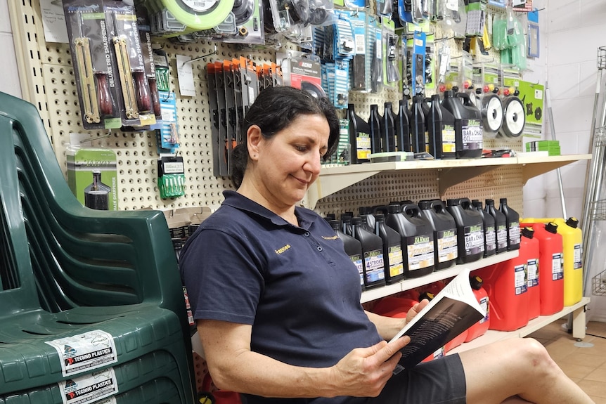 Lady reading a book in a hardware store