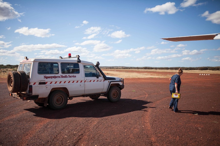 A clinic worker collects a delivery at the Cosmo Newbery airstrip, WA.