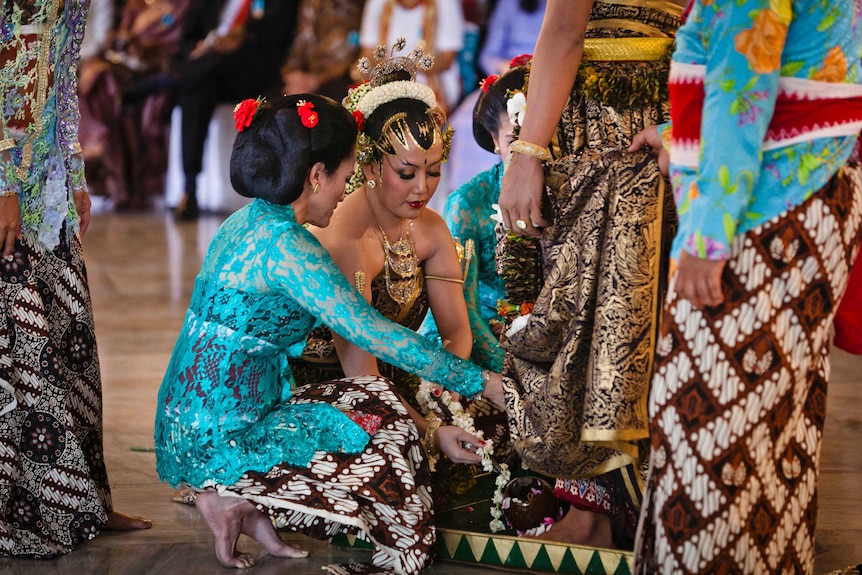 Indonesian Princess is dressed in traditional clothing and washes the feet of a royal family member.