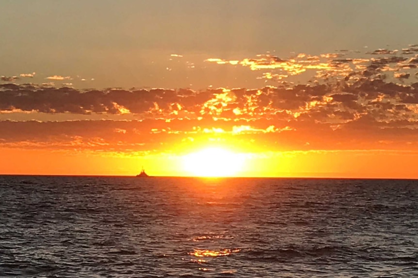 A bright orange sunset over the ocean.