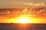 A bright orange sunset over the ocean.