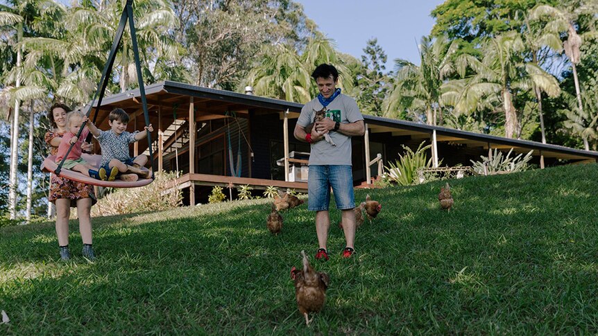 Christy and DJ with their children and chickens on the farm.