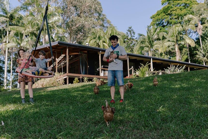 Christy and DJ with their children and chickens on the farm.