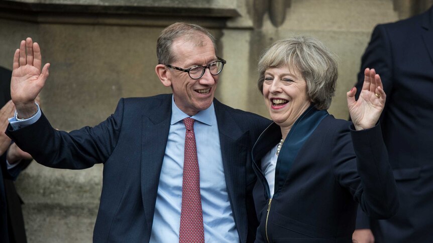 Theresa May and her husband Philip May wave to media and supporters.
