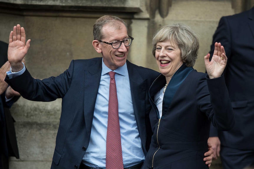 Theresa May and her husband Philip May wave to media and supporters.