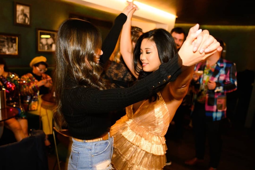 Two girls dance in a bar