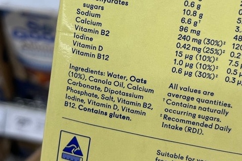 A label showing the nutritional information and ingredients on a yellow almond milk carton.